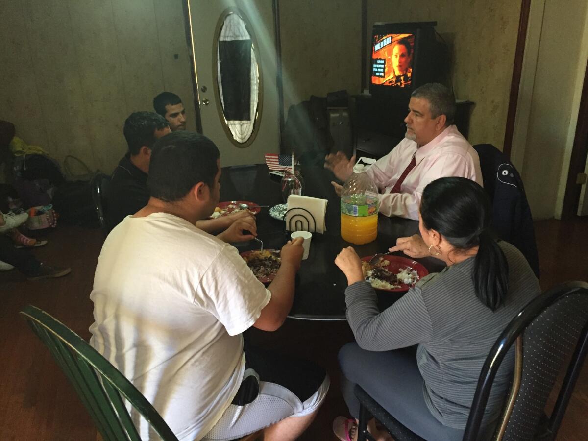 Alejandro Ruiz, in tie, at one of the homes he runs for newly arrived Cuban migrants.