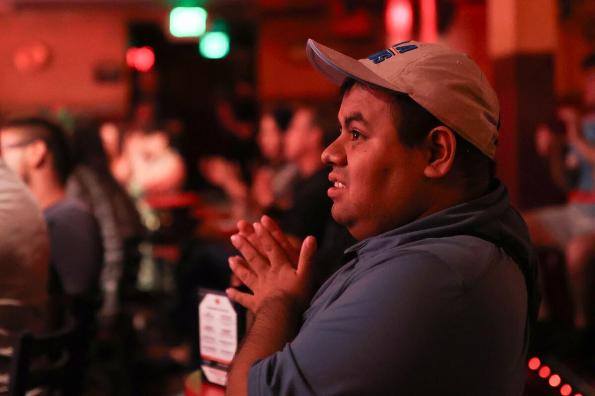 A young man claps during a comedy show at the Laugh Factory.