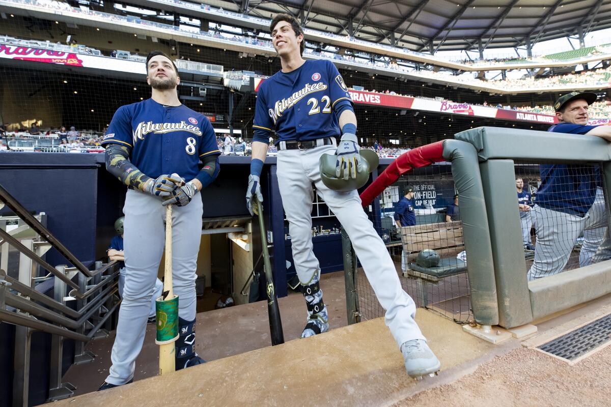Ryan Braun (8) and Christian Yelich (22), who grew up in Southern California, stand in the dugout prior to a game against the Braves on May 18 at SunTrust Park.