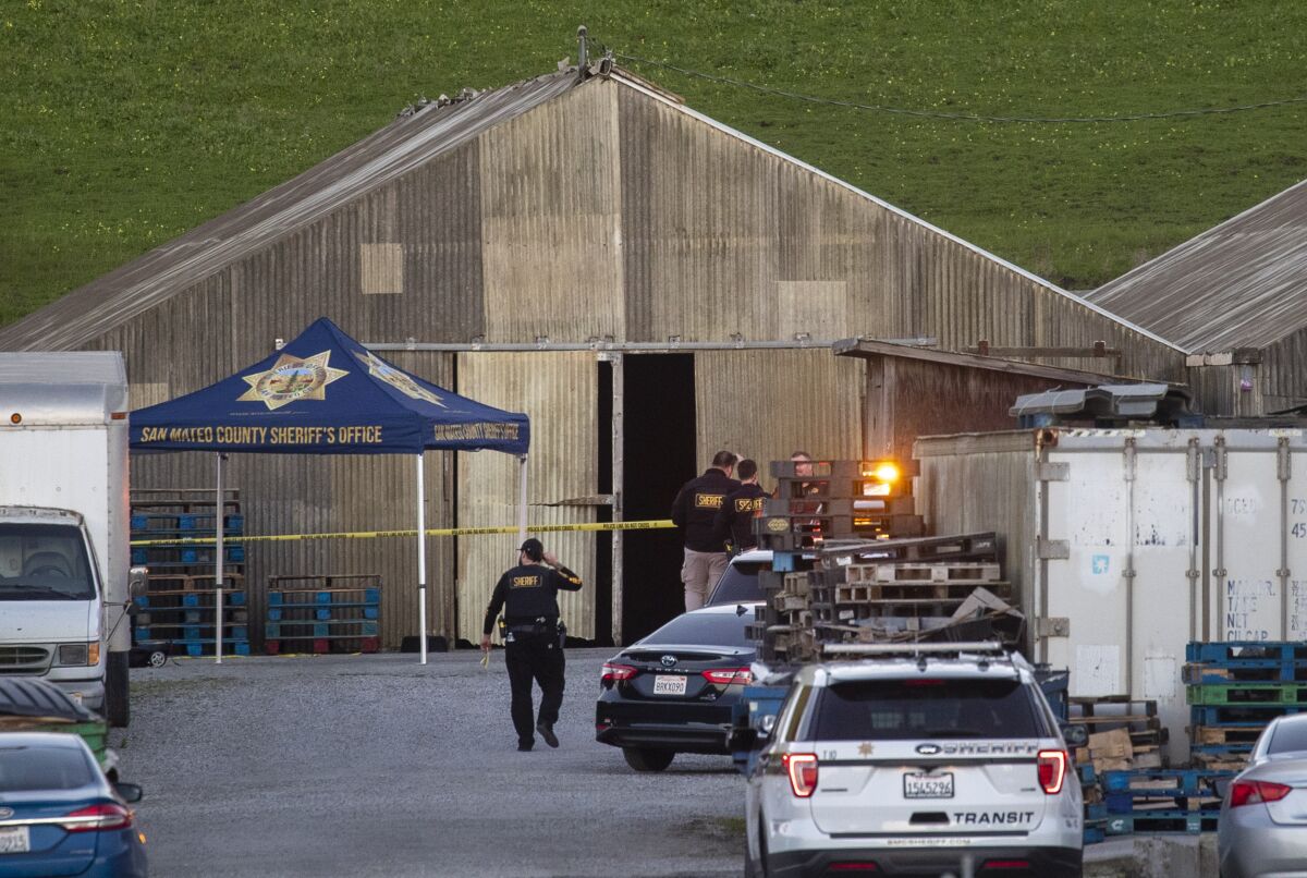 Police work around a corrugated panel building