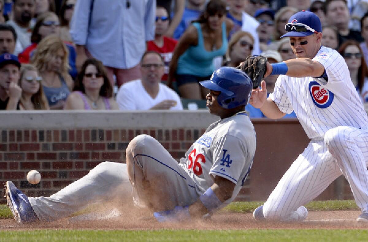 Dodgers right fielder Yasiel Puig slides safely into third base in the third inning Saturday.