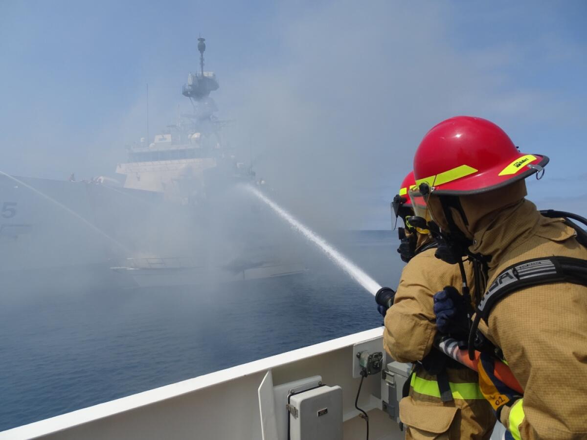 Firefighters spray water on a boat 