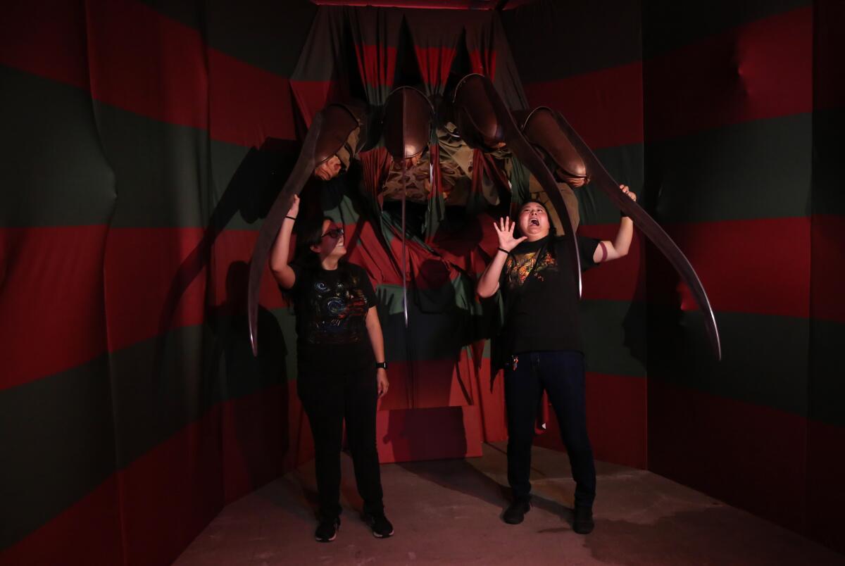 Cynthia Salazar, left, and Chelsea Salazar pose for a picture at the "I Like Scary Movies" art exhibit in downtown Los Angeles.