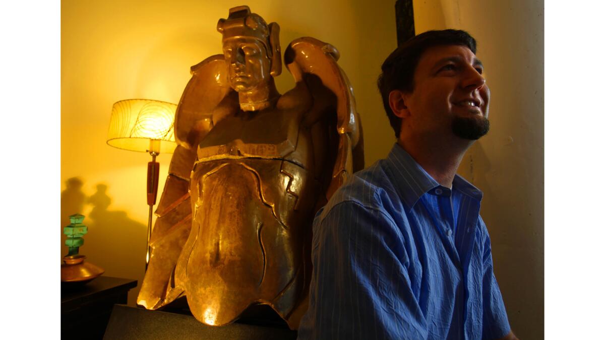 Dec. 17, 2010: Eric Lynxwiler with a former Richfield Building terra cotta angel in his Los Angeles living room.