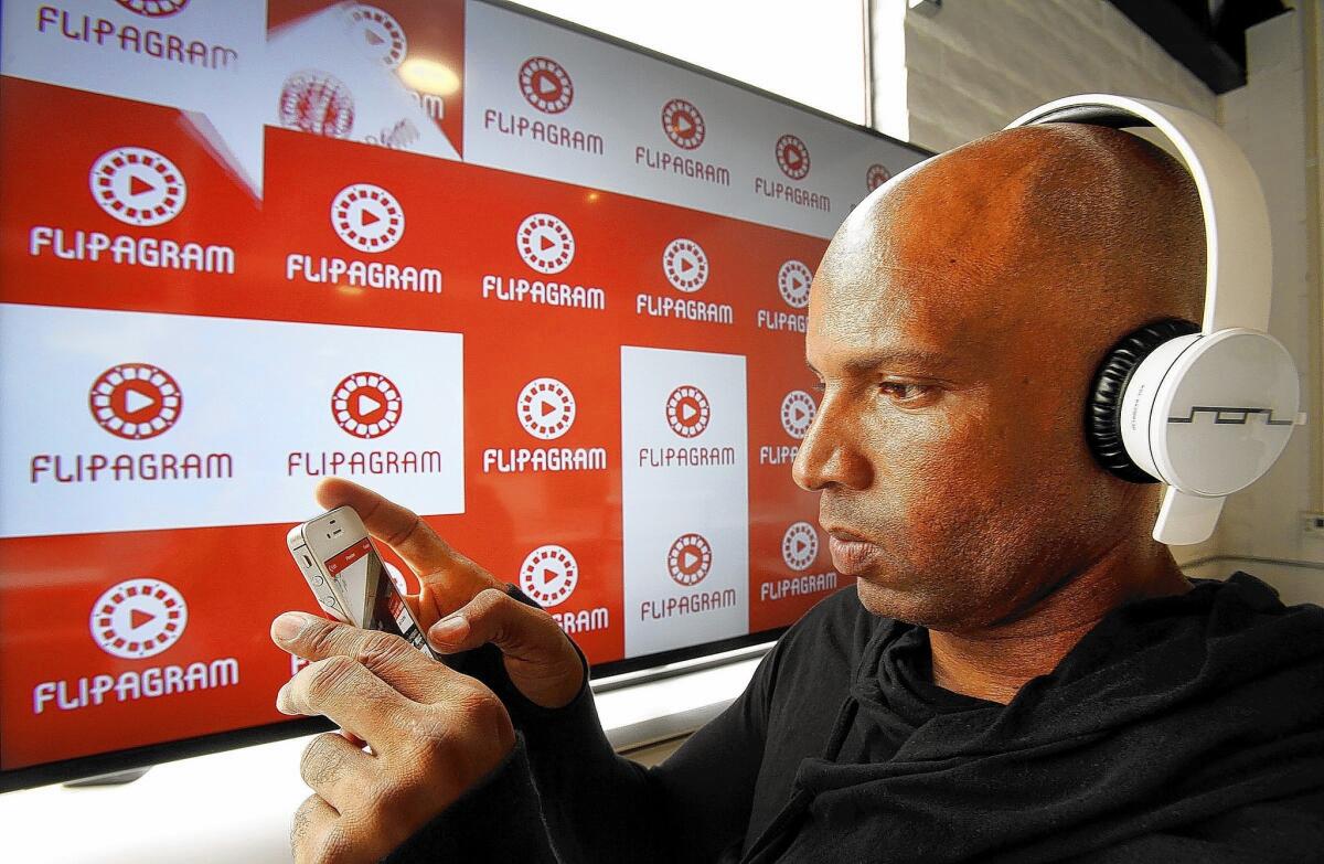 Phoenix Normand listens to his mobile app at Flipagram, which allows cellphone or Facebook photos to be set to music and made into a video album.