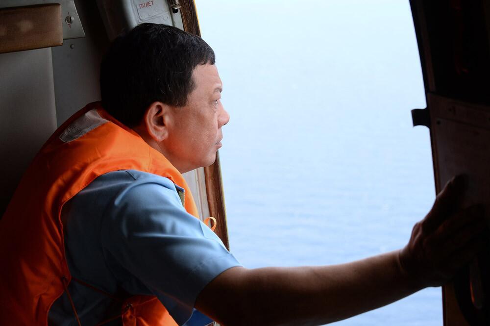 This picture taken aboard a Vietnamese Air Force's Russian-made MI-171 helicopter shows Vietnam Air Force Deputy Commander General Do Minh Tuan looking out from a door during a search flight over the southern Vietnamese waters off Vietnam's island Phu Quoc on March 11.