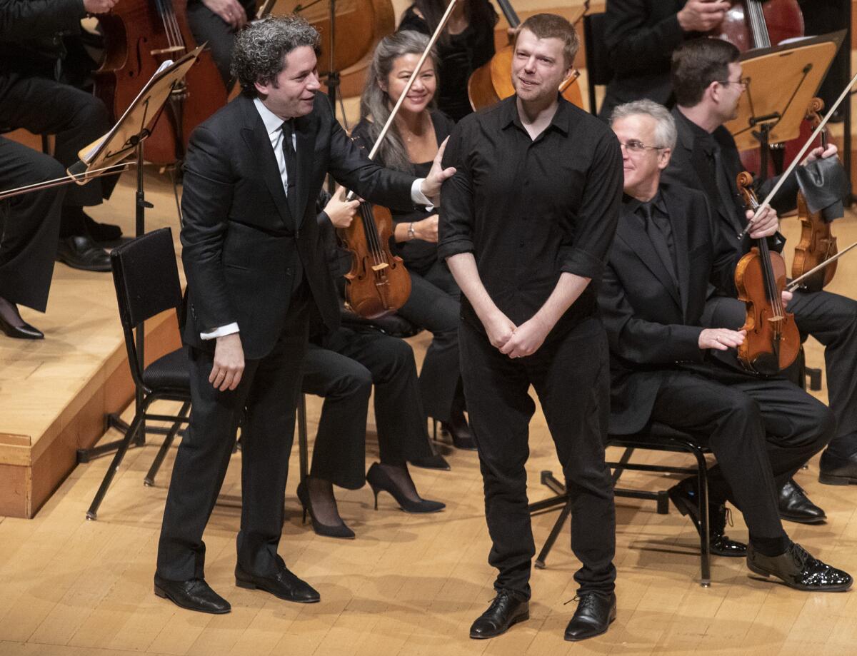 L.A. Phil conductor Gustavo Dudamel takes in applause with composer Andrew Norman.
