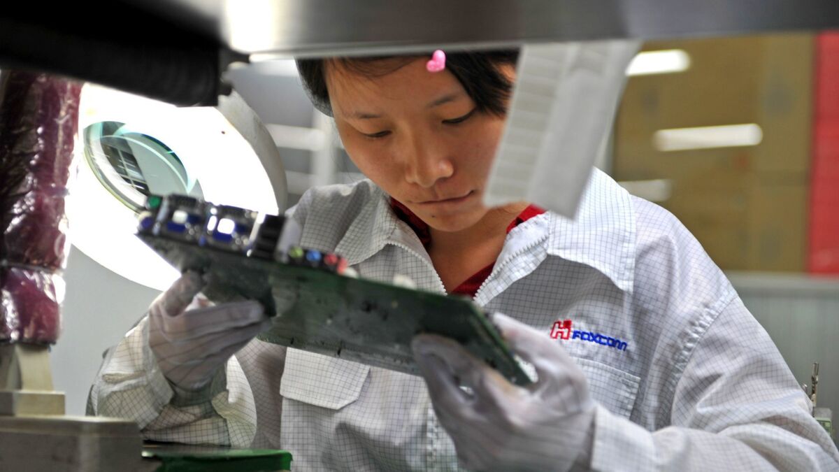 A worker inspects a motherboard on a factory line at the Foxconn plant in Shenzen, China, in 2010.