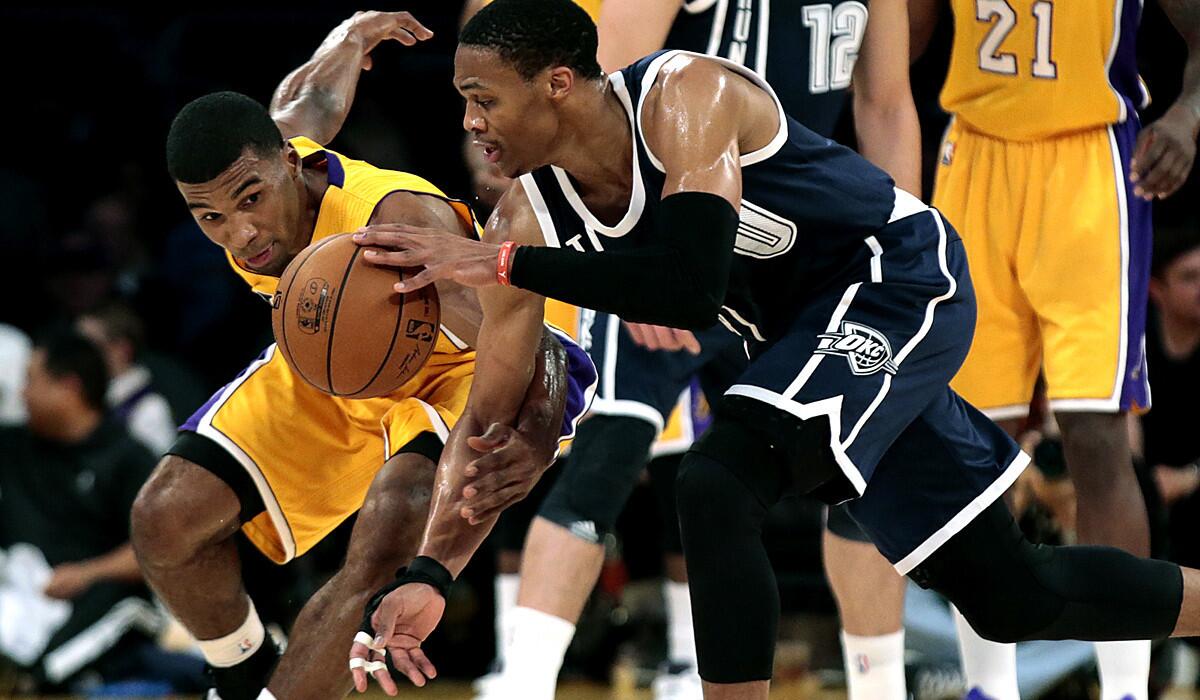 Lakers point guard Ronnie Price attempts to steal the ball from Thunder point guard Russell Westbrook in the first half.