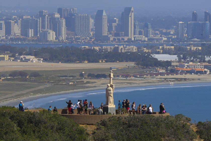 People gather at the Cabrillo National Monument on the end of Point Loma to view the city skyline.