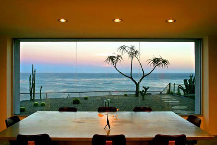 A clean simplicity rules the Malibu home of artist Charles Arnoldi and wife, Katie, a novelist. He designed the house as well as most of its furniture, including an aluminum dining table topped with a small Calder sculpture. Arnold Schwarzenegger liked the table so much that he commissioned one for himself, Charles says. Outside the window is the silhouette of an aloe tree, backed by a sunset over the Pacific.