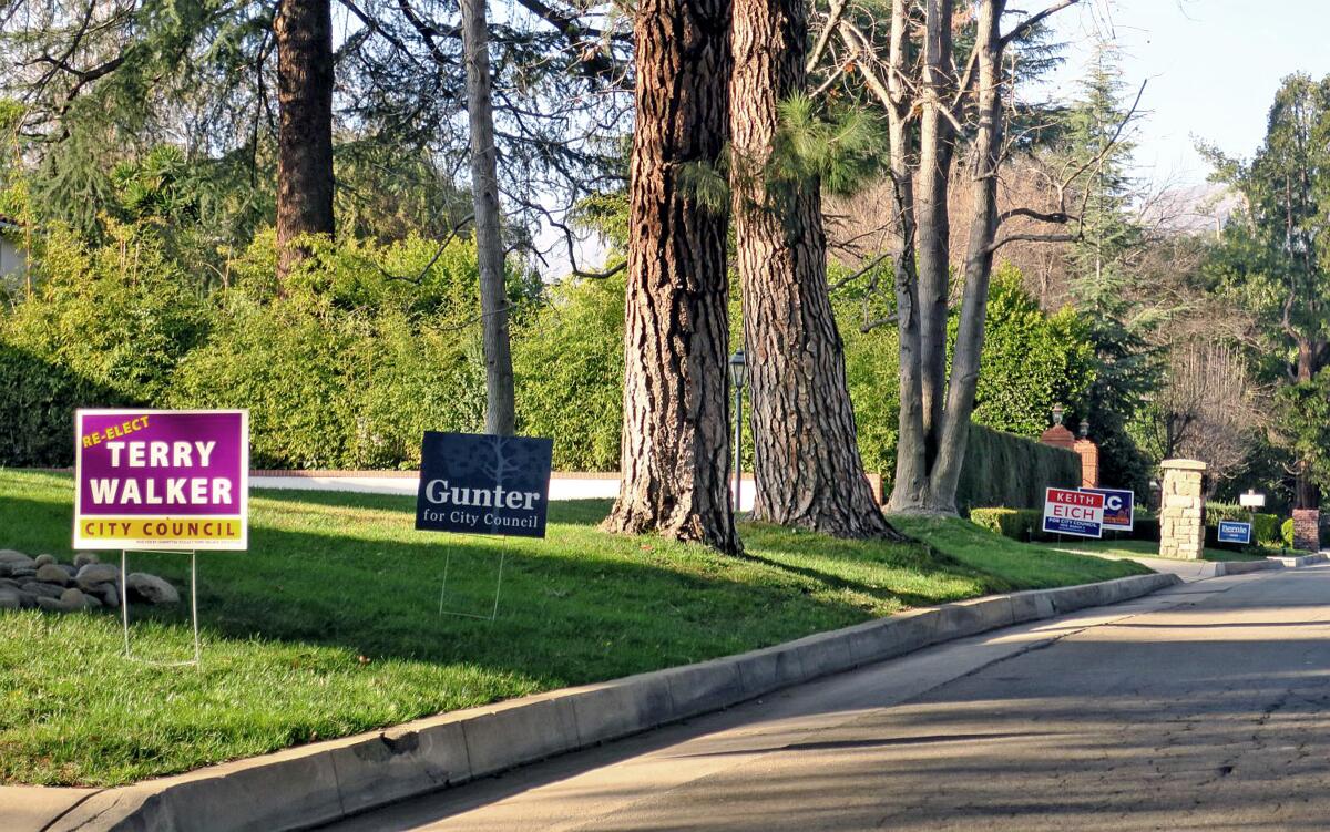 A homeowner on La Cañada's Commonwealth Avenue displays yard signs for various candidates and measures in the March 3 election.