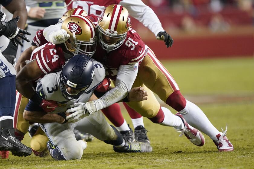 Seattle Seahawks quarterback Russell Wilson, bottom, is tackled under San Francisco 49ers defensive back K'Waun Williams (24) and defensive end Arik Armstead (91) during an NFL football game in Santa Clara, Calif., Monday, Nov. 11, 2019. (AP Photo/Tony Avelar)