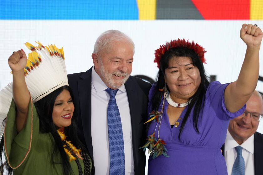 FILE - The new Minister of Indigenous Peoples, Sonia Guajajara, left, Brazil's President Luiz Inacio Lula da Silva, center, and the new President of the National Foundation of the Indian, Joenia Wapichana, celebrate during their inauguration ceremony at Planalto Palace in Brasilia, Brazil, Jan. 11, 2023. In a rejection of early moves by Lula who took office in January, Brazil’s Congress on June 1, 2023 stripped powers from the new Ministry of Indigenous Peoples and Ministry of the Environment and Climate Change, both led by women environmentalists. (AP Photo/Eraldo Peres, File)