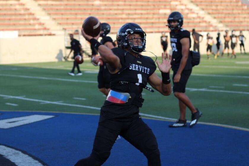 Servite quarterback Noah Fifita warms up before a game against Edison.