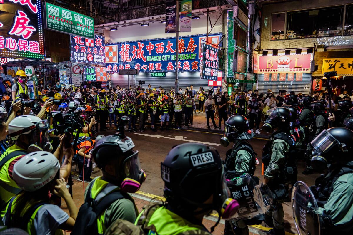 Journalist and police officers in a stand off, in the commercial neighborhood of Mong Kok.