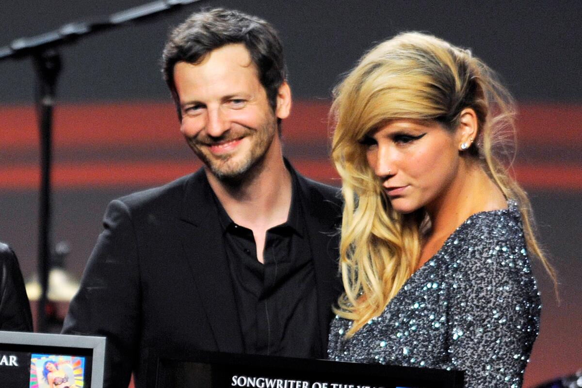 Dr. Luke and Kesha stand at an awards show. 