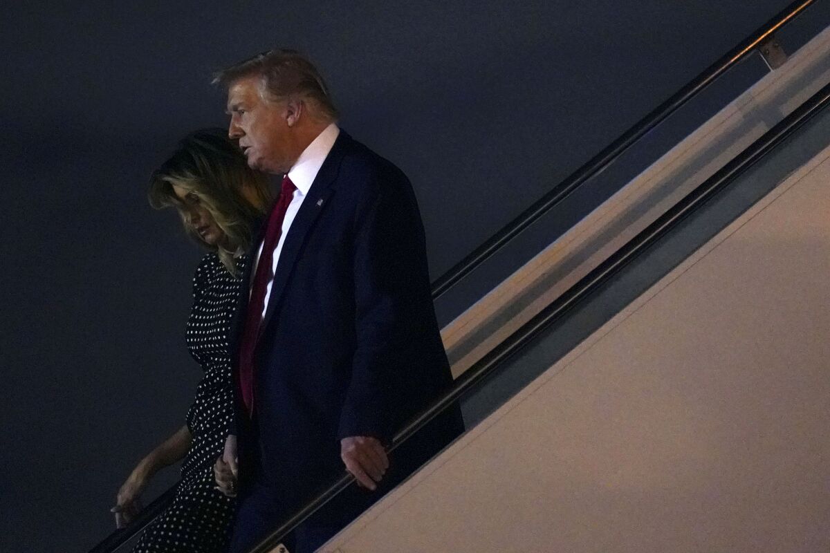 President Trump and Melania Trump descend stairs from Air Force One.