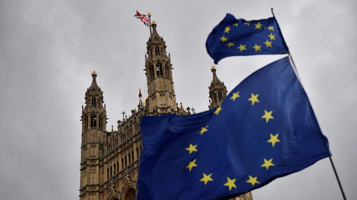 European Union flags held by demonstrators flutter in front of the Houses of Parliament in central London on April 4, 2019.
