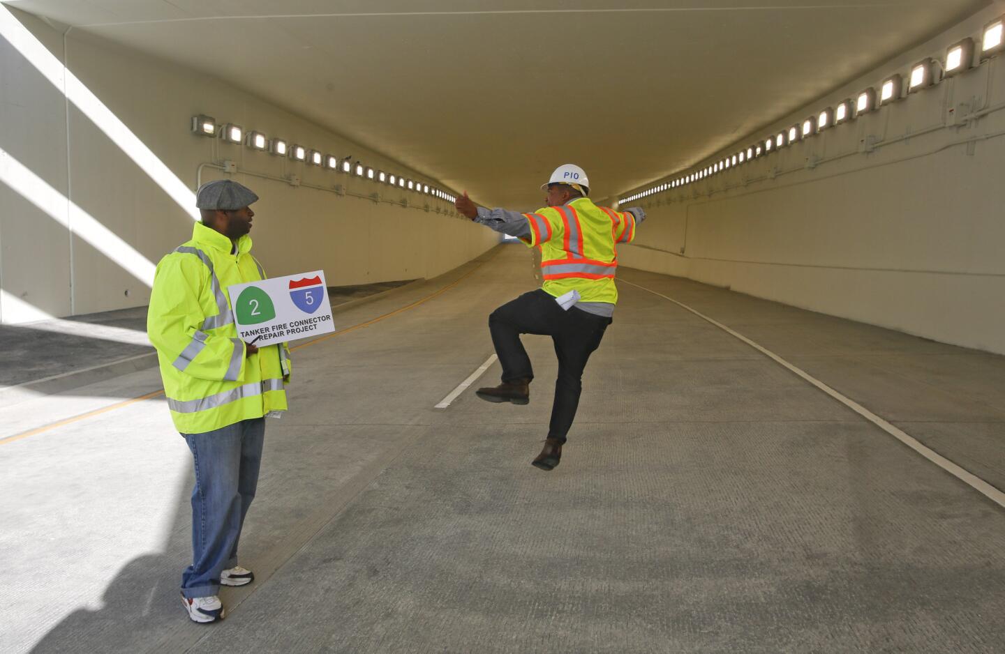 Caltrans officials Peter Jones, left, and Patrick Chandler celebrate the reopening of the underpass connecting the Glendale Freeway with the northbound 5 freeway in Los Angeles,