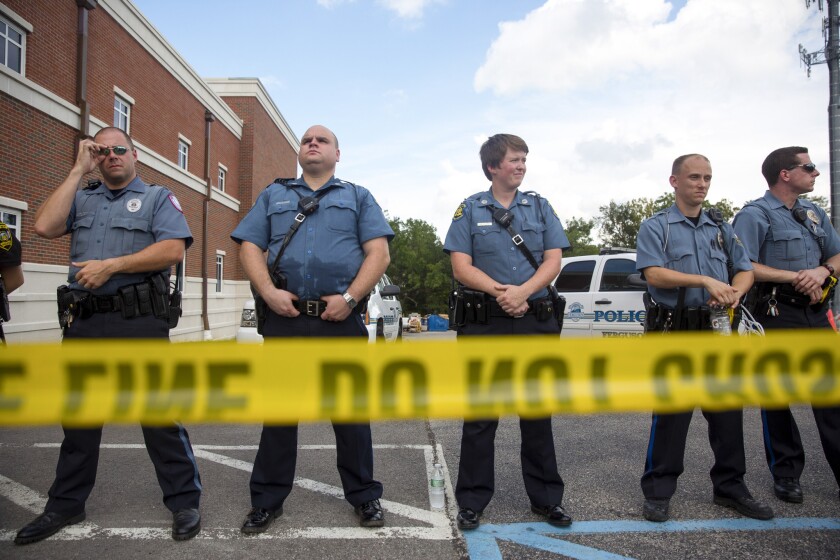Police stand guard during an Aug. 30 rally for Michael Brown outside the Ferguson Police Department in Missouri.