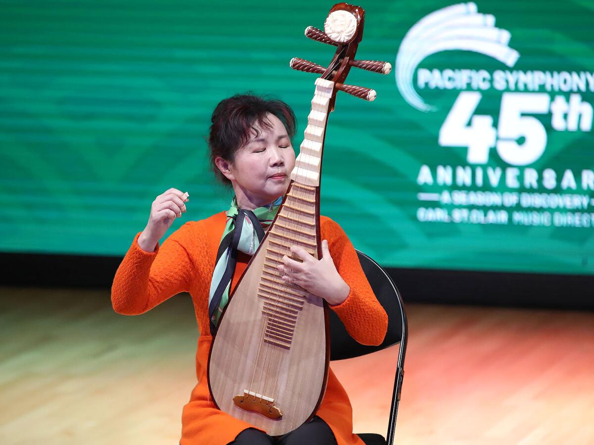 Yu Liu plays the pipa as she performs a piece from the concert music.
