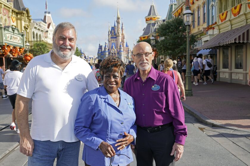 Walt Disney World employees from left, Chuck Milam, Earliene Anderson and Forrest Bahruth gather at the Magic Kingdom Monday, Aug. 30, 2021, in Lake Buena Vista, Fla. to celebrate their 50 years working at the park. (AP Photo/John Raoux)