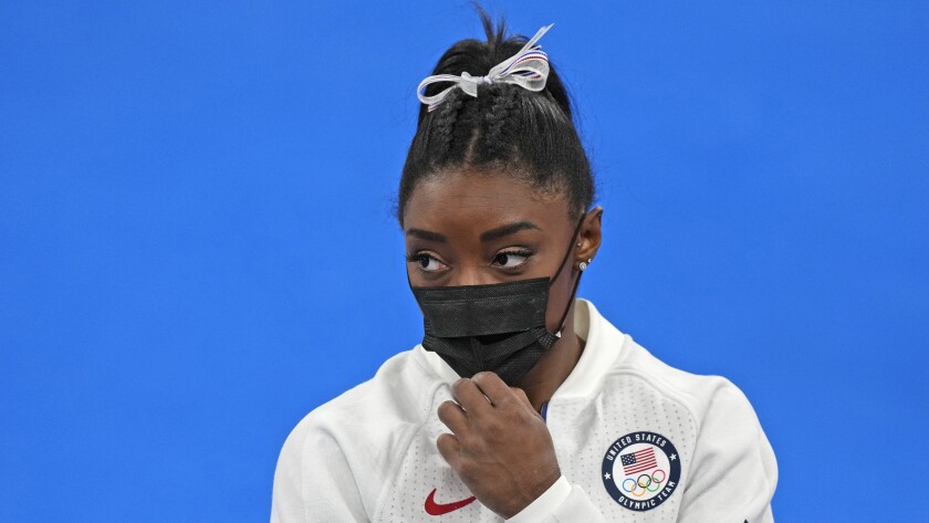 Simone Biles stands on the sideline wearing a mask after she exited the team final Tuesday.