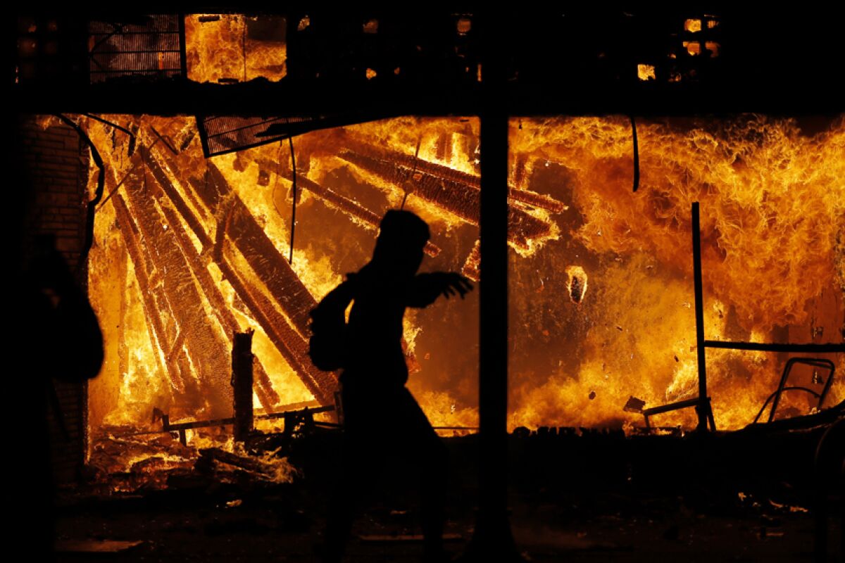 A protester runs in front of the burning  police station May 28 in Minneapolis.