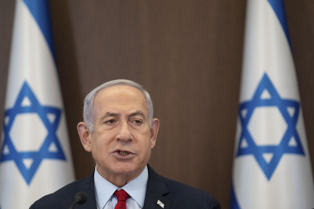 Israeli Prime Minister Benjamin Netanyahu in front of two Israeli flags 