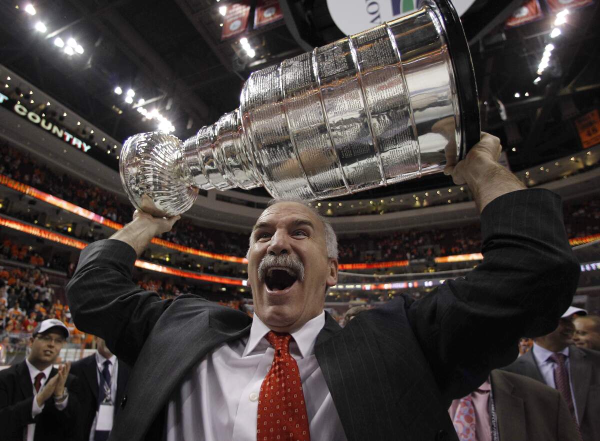 Chicago Blackhawks coach Joel Quenneville raises the Stanley Cup in 2010.