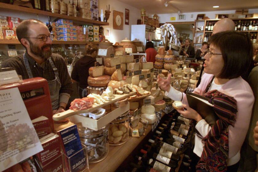 Norbert Wabnig, owner of the The Cheese Store in Beverly Hills, talks to Mamie Warrick, right, who is with a tour group from a conference on marketing luxury goods to the wealthy.