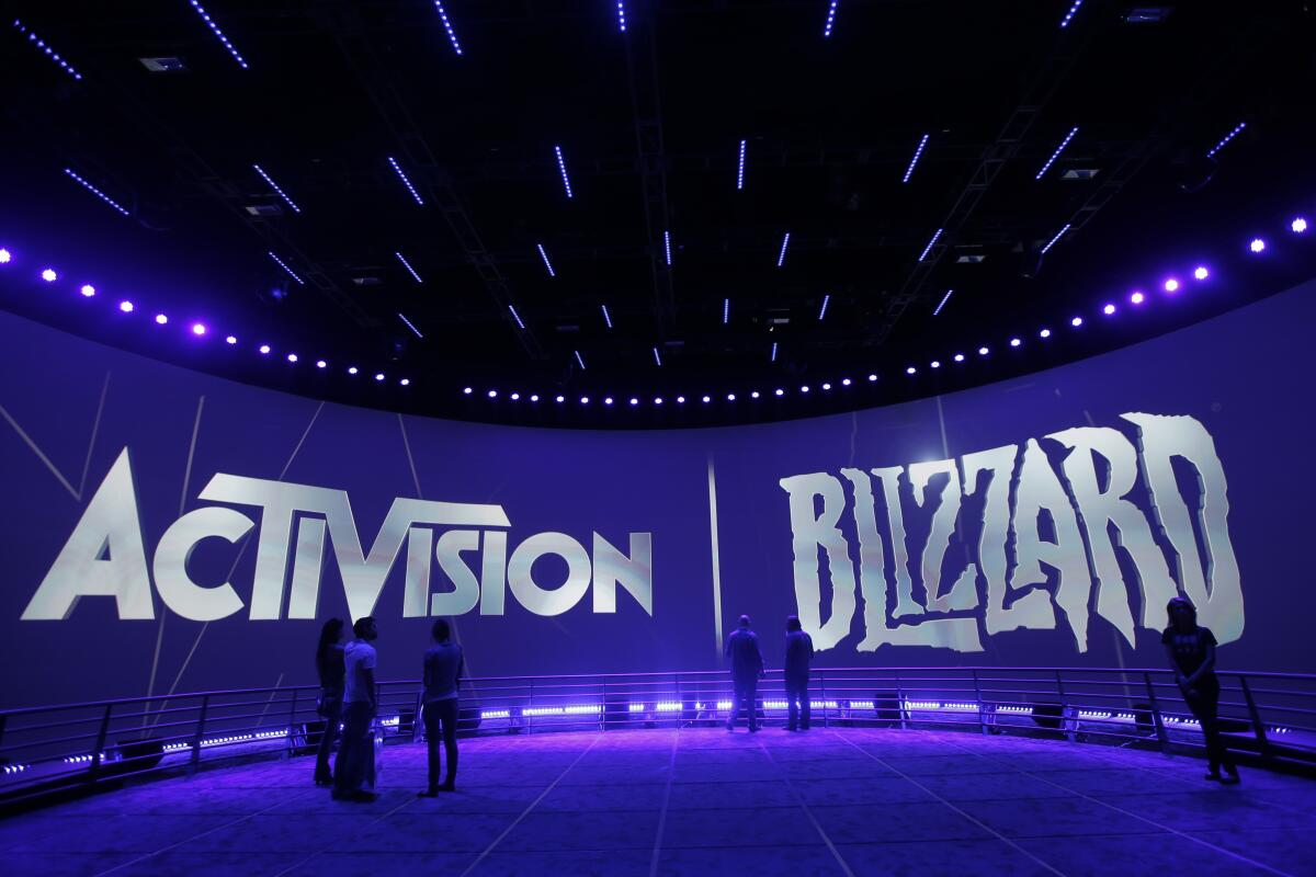 A blue wall with the words "Activision" and "Blizzard" on an expo booth.
