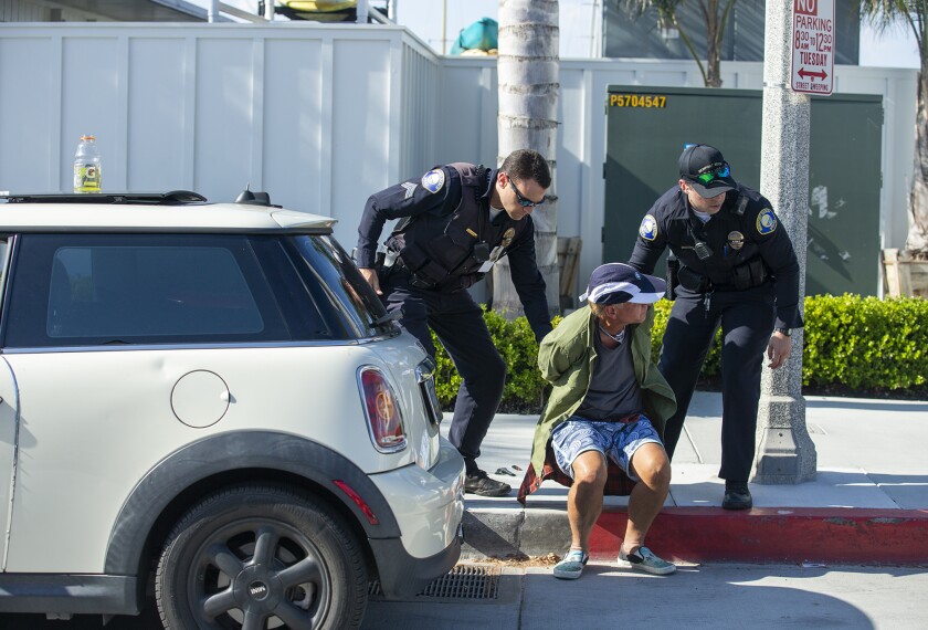 Newport Beach police arrest a man suspected of driving his car into a crowd of protesters.