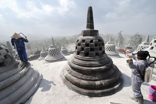 Workers protect the stupa from ash