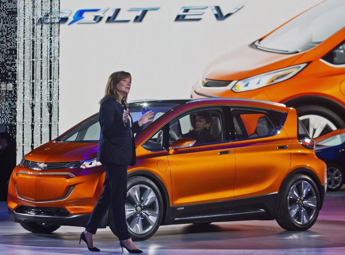General Motors Chief Executive Mary Barra stands near a Chevy Bolt EV.