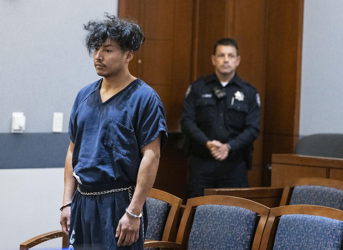 Yoni Christian Barrios wearing jail garb and restraints in a courtroom
