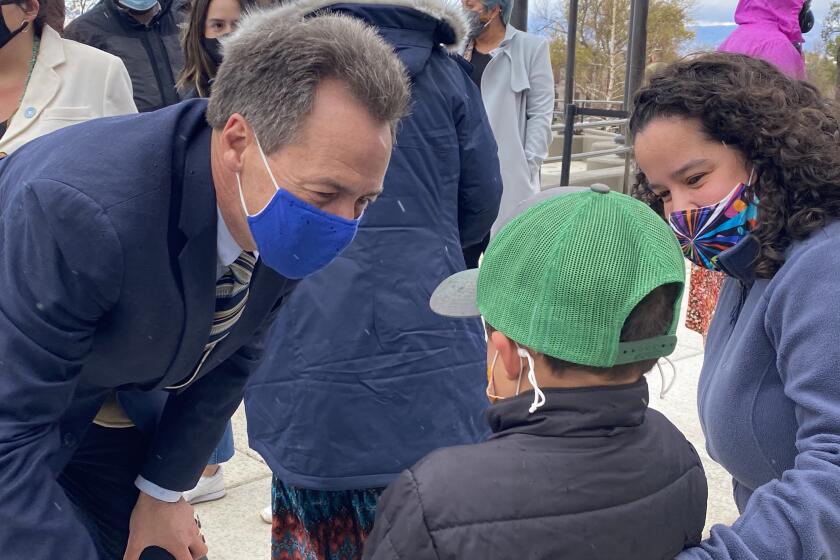 Montana Gov. Steve Bullock, a Democrat running for U.S. Senate, meets future voter Archer James, 6, as his mother, Lisa, looks on.