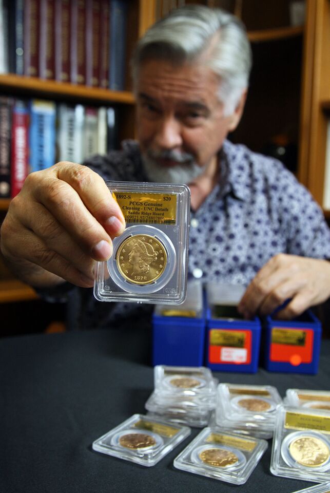 David Hall of Professional Coin Grading Service in Santa Ana shows one of the 1,427 U.S. gold coins found buried in Northern California. Nearly all of the coins, dating from 1847 to 1894, are in uncirculated, mint condition, said Hall.