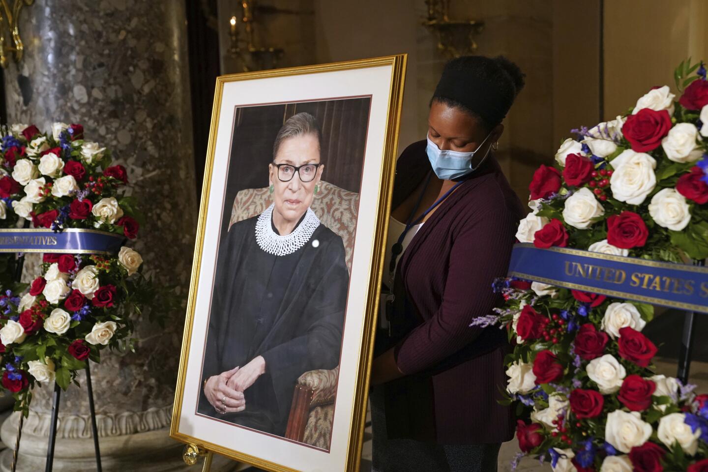 A staff member places a photo of Justice Ruth Bader Ginsburg.