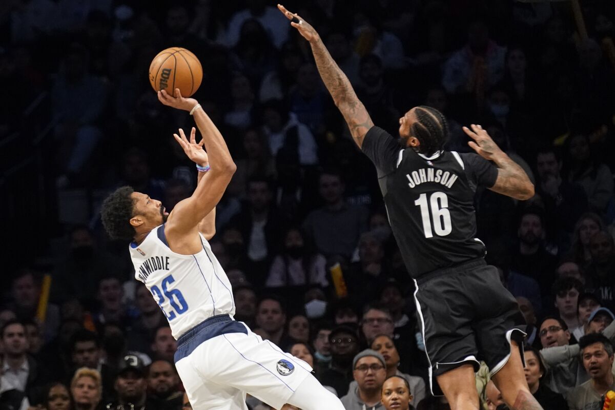 Dallas Mavericks guard Spencer Dinwiddie (26) shoots against Brooklyn Nets forward James Johnson (16) in the second half of an NBA basketball game, Wednesday, March 16, 2022, in New York. (AP Photo/John Minchillo)