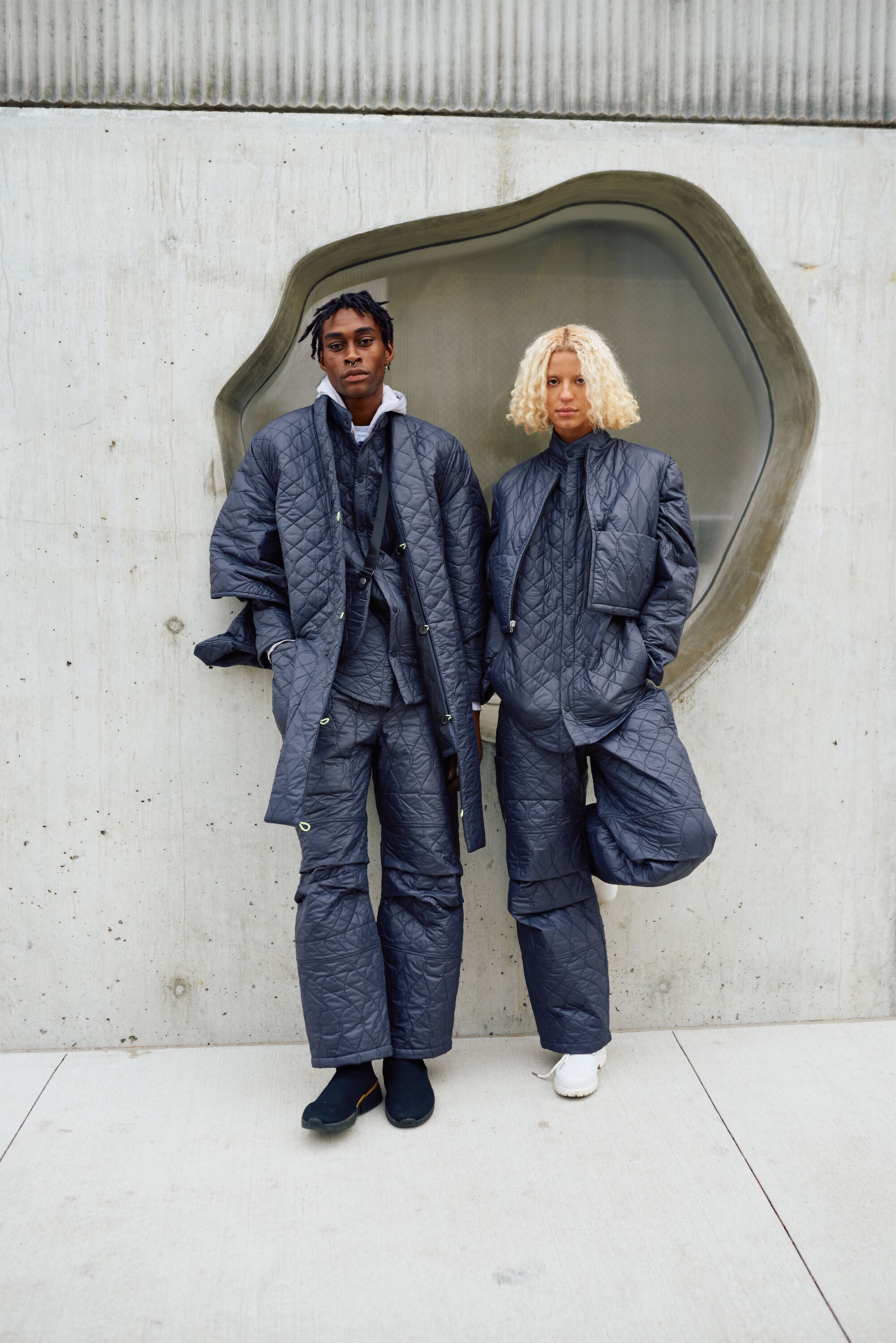 A male and female model in quilted blue clothing