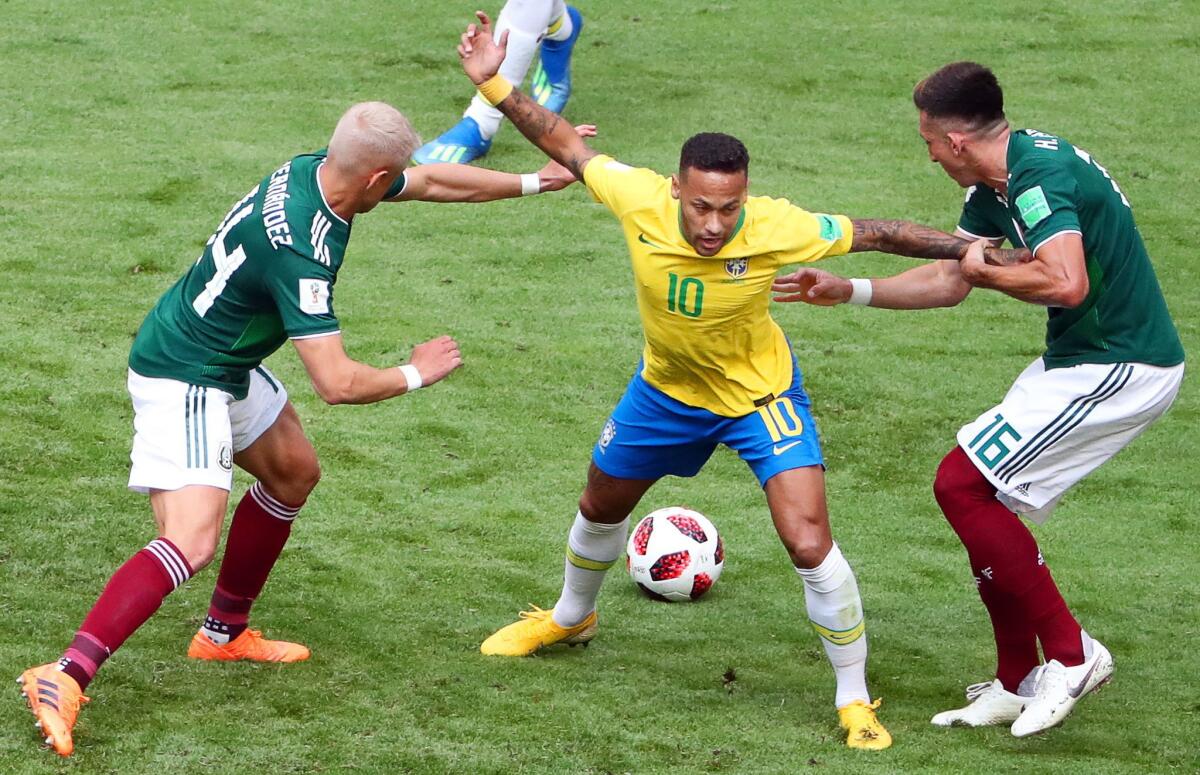 Neymar (C) of Brazil in action against Mexican players Javier Hernandez (L) and Hector Herrera (R) during the FIFA World Cup 2018 round of 16 soccer match between Brazil and Mexico in Samara, Russia, 02 July 2018.