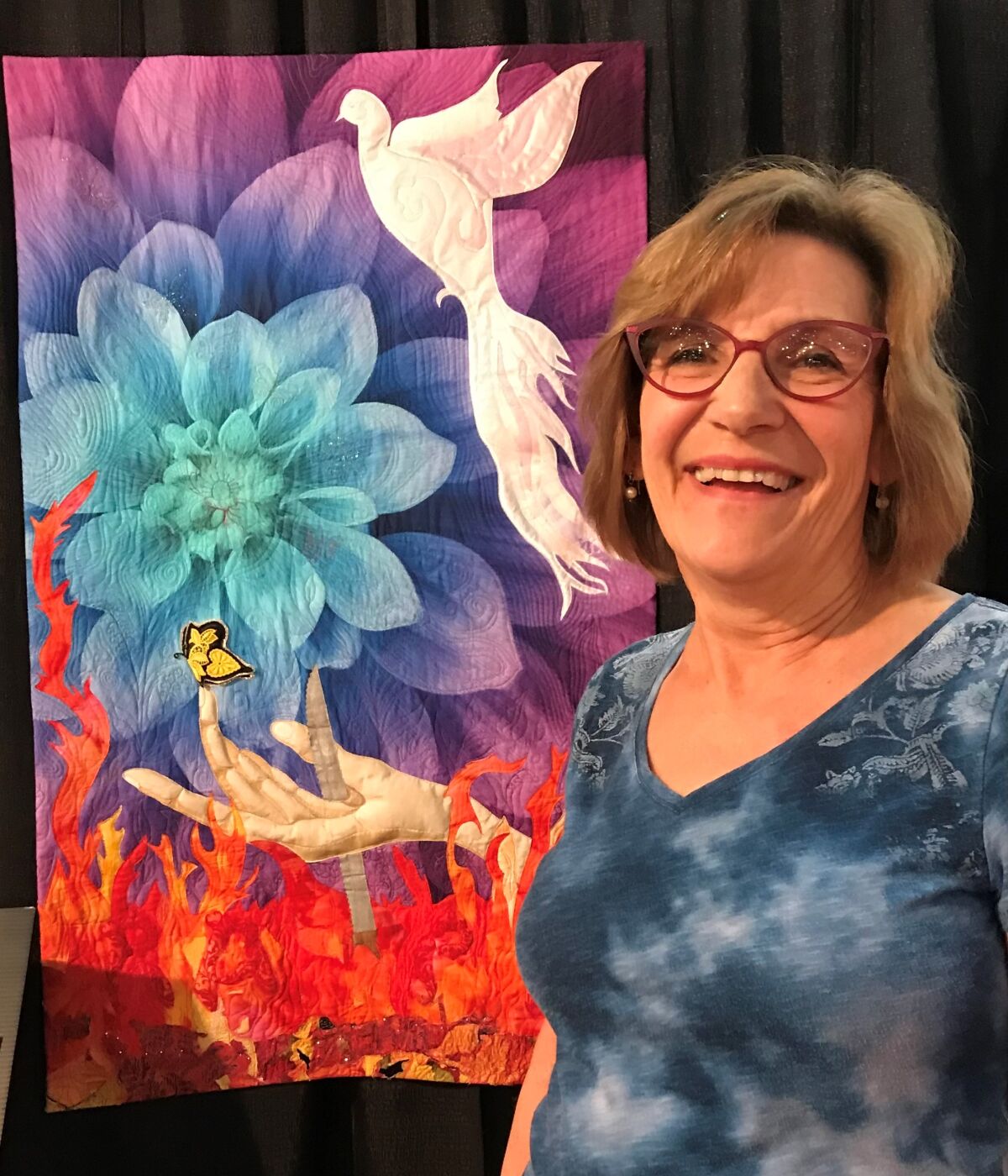Valerie Paterson next to her quilt, "Hell and Hope," currently on display at Visions Art Museum in San Diego through April 3