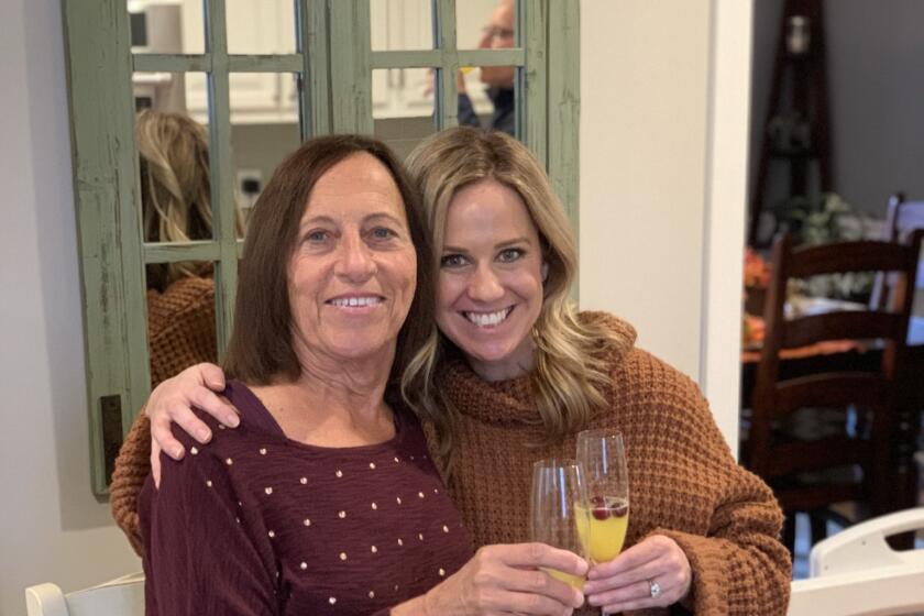 A woman and her adult daughter celebrate with champagne glasses.