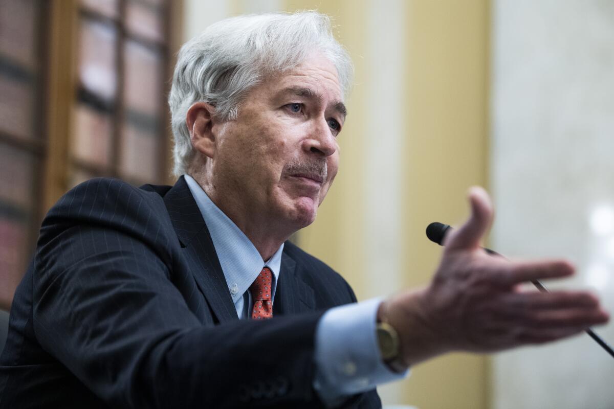 Central Intelligence Agency director William Burns gestures as he speaks into a microphone.