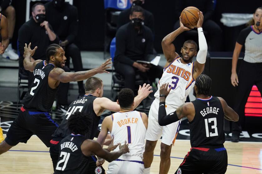 Phoenix Suns guard Chris Paul (3) passes over a group of Los Angeles Clippers defenders during the first half of an NBA basketball game Thursday, April 8, 2021, in Los Angeles. (AP Photo/Marcio Jose Sanchez)