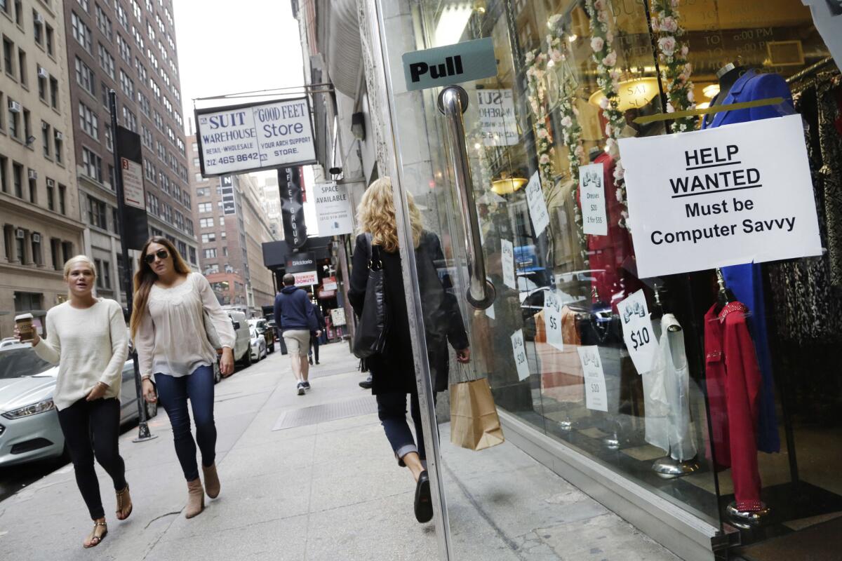 A "Help Wanted" sign hangs in a store window in New York City on Oct. 1.