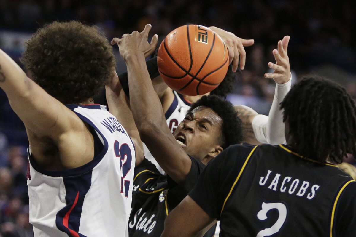 Kent State forward Miryne Thomas, center, goes after a rebound near guard Malique Jacobs, right, against Gonzaga forward Anton Watson, left, and guard Julian Strawther during the second half of an NCAA college basketball game, Monday, Dec. 5, 2022, in Spokane, Wash. Gonzaga won 73-66. (AP Photo/Young Kwak)