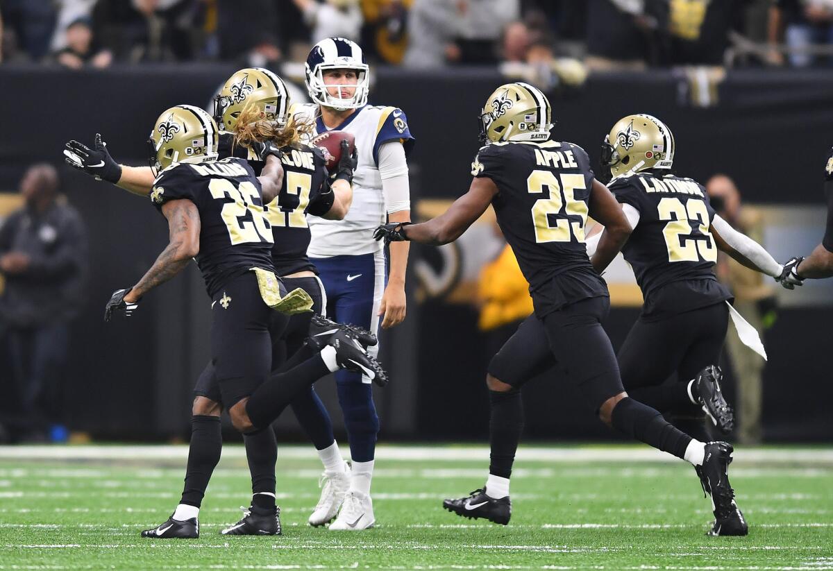 Rams quarterback Jared Goff can only watch as New Orleans Saints players celebrate an interception late in the second quarter that led to a touchdown at the Mercedes-Benz Superdome in New Orleans on Sunday.